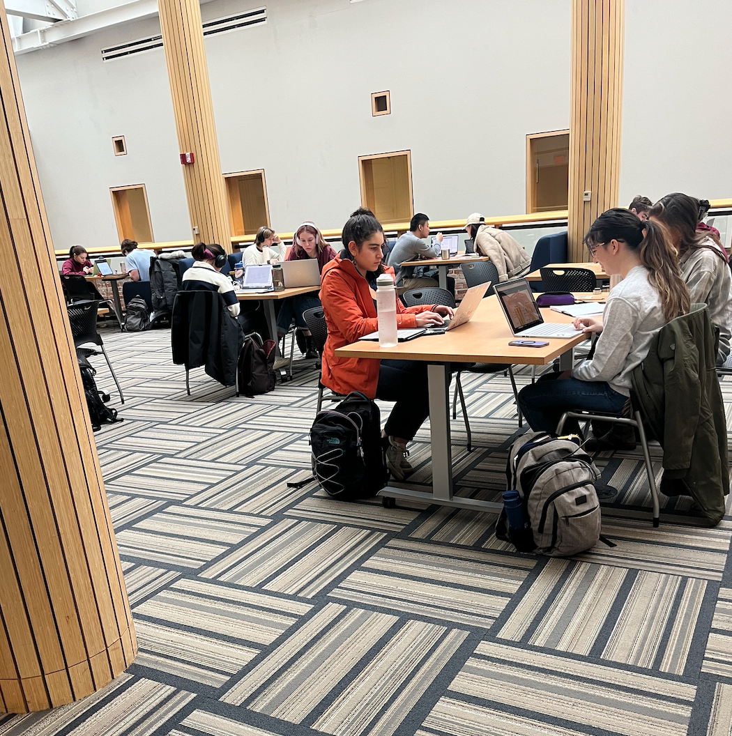 Several tables with groups of 4 students studying at each table.