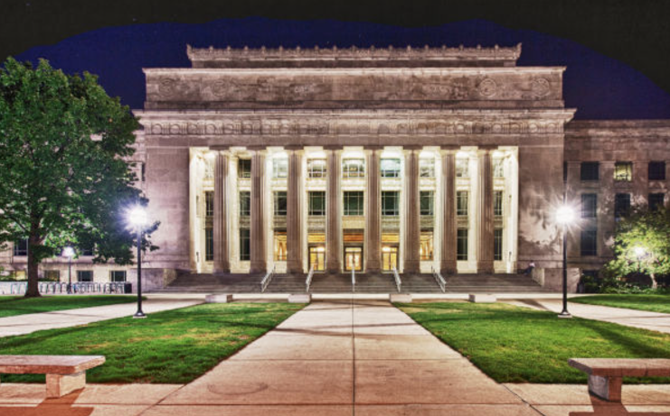 This image shows the front of Angell Hall during an evening hour (it's dark outside). The two lights in front of the hall are lit and it's a peaceful image as there are no people in this picture. The image is meant to depict the beauty of Angell Hall.